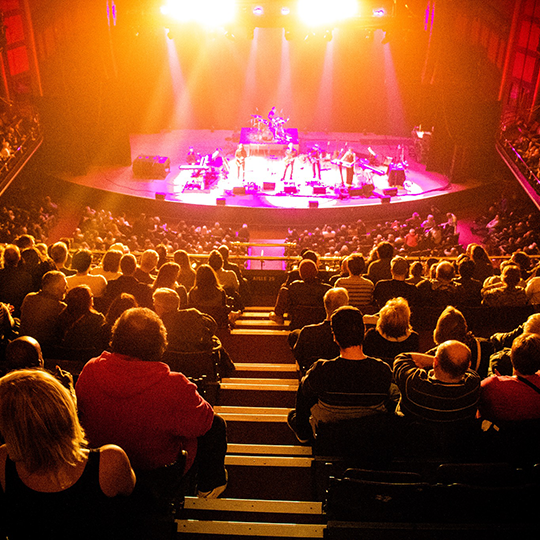 Band plays onstage to a packed house.