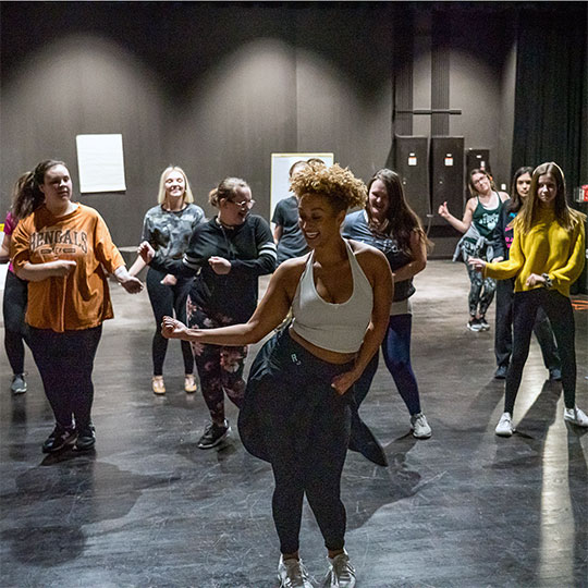 Students learn to dance from an instructor